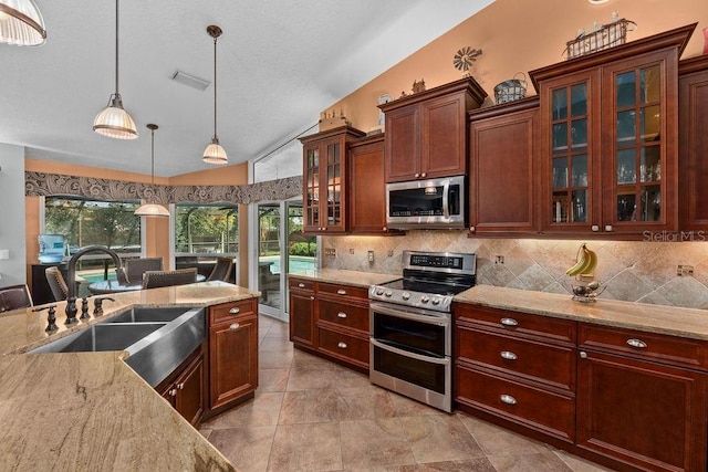 kitchen featuring a sink, visible vents, vaulted ceiling, appliances with stainless steel finishes, and tasteful backsplash