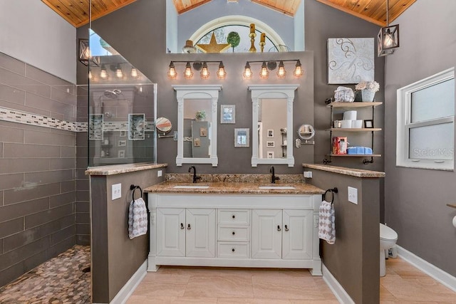 bathroom with lofted ceiling, double vanity, a walk in shower, and a sink