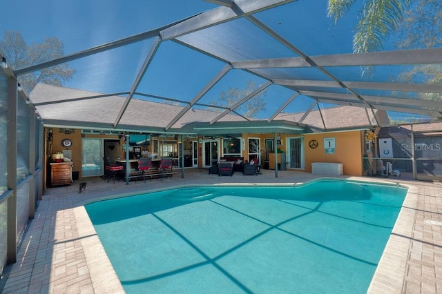 outdoor pool featuring glass enclosure and a patio