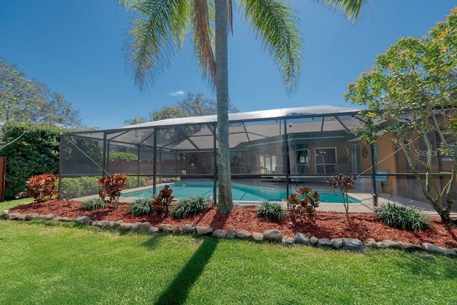 outdoor pool featuring glass enclosure and a lawn