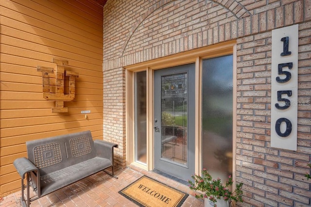 property entrance featuring brick siding