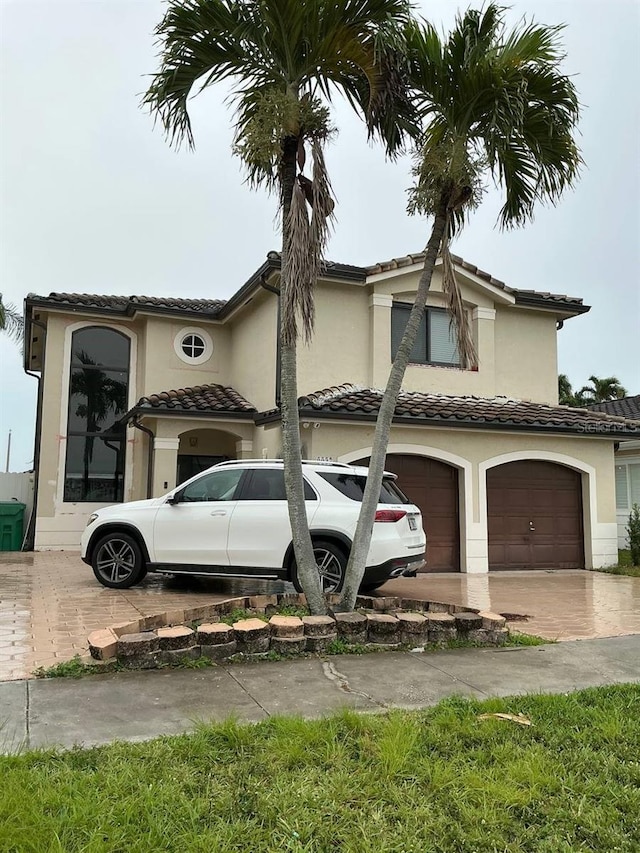 view of home's exterior featuring decorative driveway, an attached garage, and stucco siding