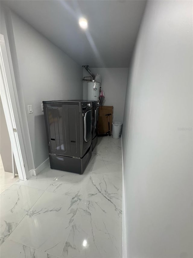 laundry area with laundry area, baseboards, marble finish floor, washing machine and dryer, and gas water heater