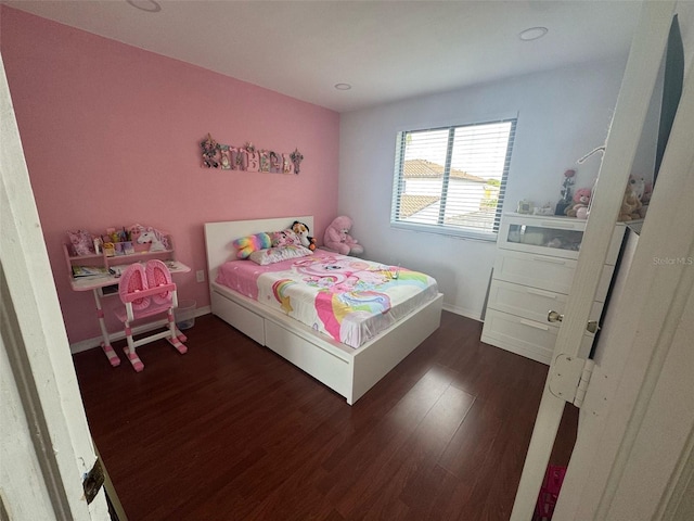 bedroom with baseboards and wood finished floors