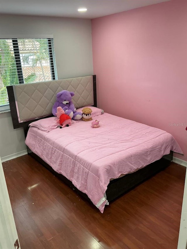 bedroom featuring baseboards and wood finished floors