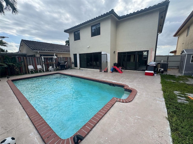 view of pool featuring a fenced in pool, a patio area, fence, and central AC