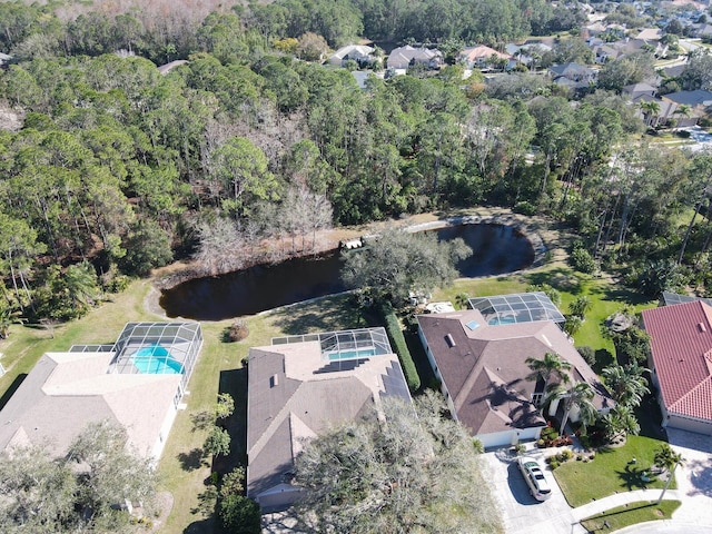 aerial view with a water view and a wooded view