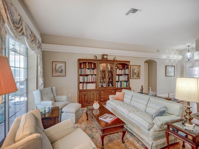 living room featuring arched walkways and visible vents