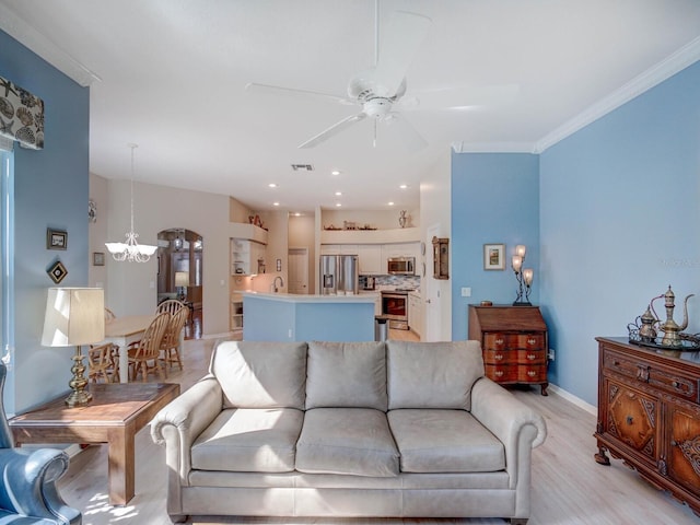 living area featuring visible vents, ornamental molding, light wood-type flooring, baseboards, and ceiling fan with notable chandelier