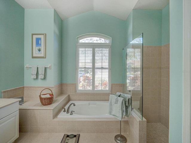 full bath with vaulted ceiling, tiled shower, a garden tub, and vanity