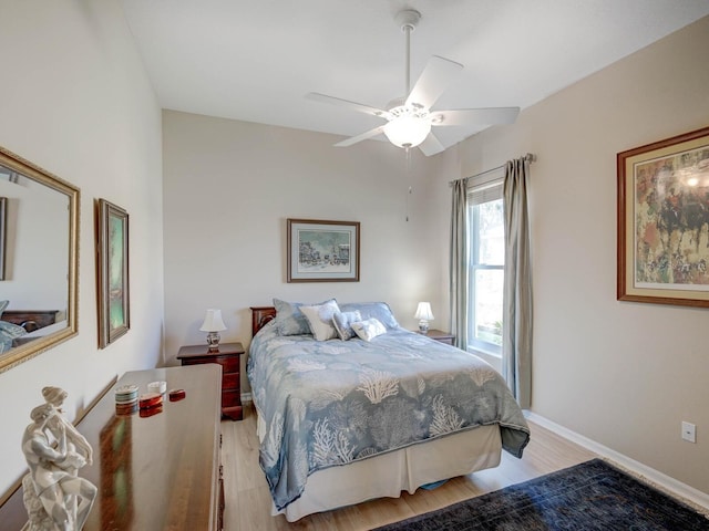 bedroom with baseboards, a ceiling fan, and light wood-style floors