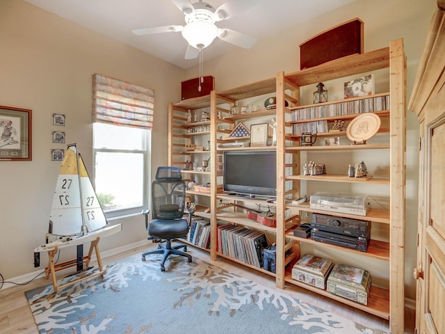 home office featuring a ceiling fan, baseboards, and wood finished floors