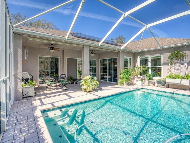 pool featuring a lanai, a patio area, and a ceiling fan