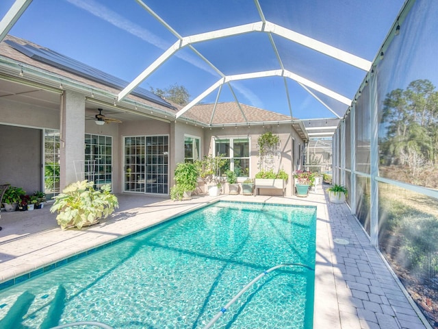 pool with a lanai, a patio area, and ceiling fan