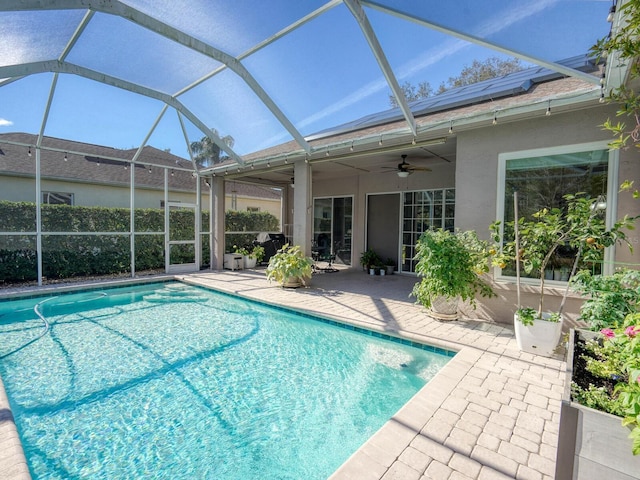 view of swimming pool with a ceiling fan, glass enclosure, a fenced in pool, and a patio area