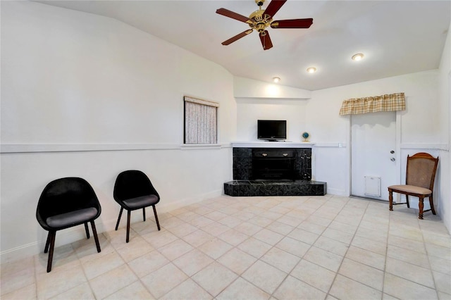 sitting room with light tile patterned floors, lofted ceiling, a premium fireplace, ceiling fan, and baseboards