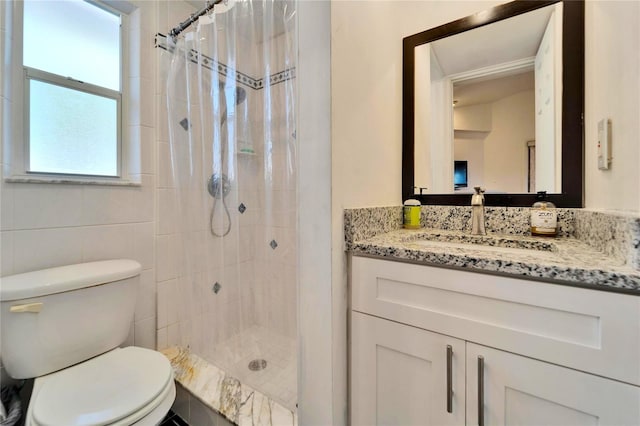 bathroom featuring tiled shower, vanity, and toilet