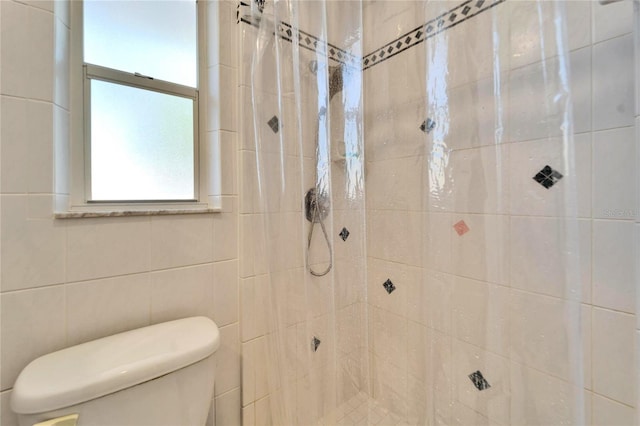 full bathroom featuring toilet and tiled shower