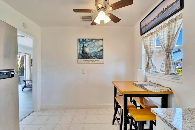 dining area with visible vents, ceiling fan, baseboards, and light tile patterned floors