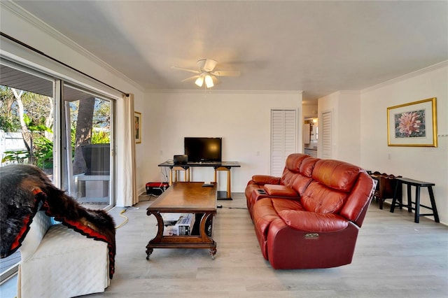 living area featuring wood finished floors, a ceiling fan, and crown molding