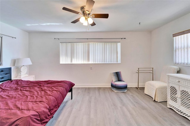 bedroom featuring a ceiling fan, baseboards, and wood finished floors