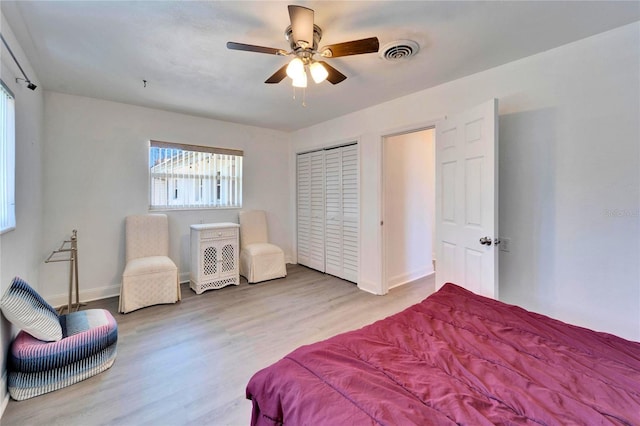 bedroom featuring baseboards, wood finished floors, visible vents, and a ceiling fan