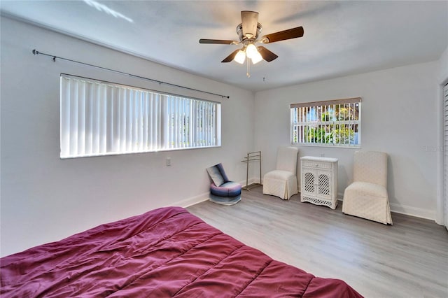 bedroom featuring wood finished floors, a ceiling fan, and baseboards