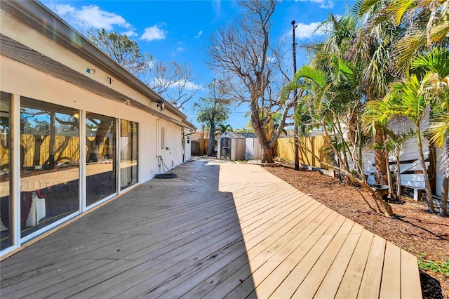 deck featuring an outbuilding, a storage unit, and a fenced backyard