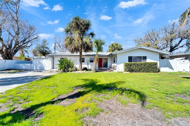 ranch-style house with an attached garage, fence, driveway, stucco siding, and a front yard