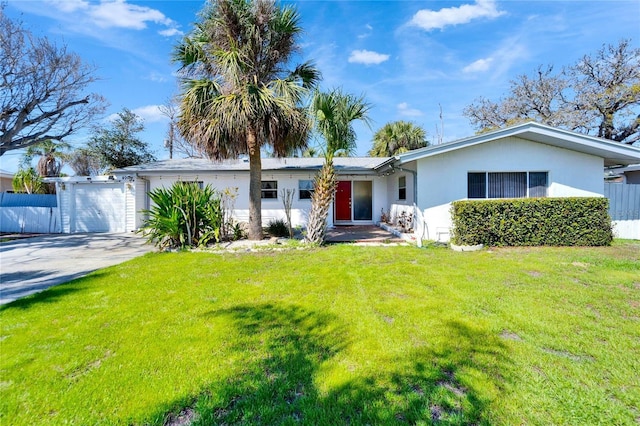 ranch-style home featuring a garage, concrete driveway, fence, a front lawn, and stucco siding