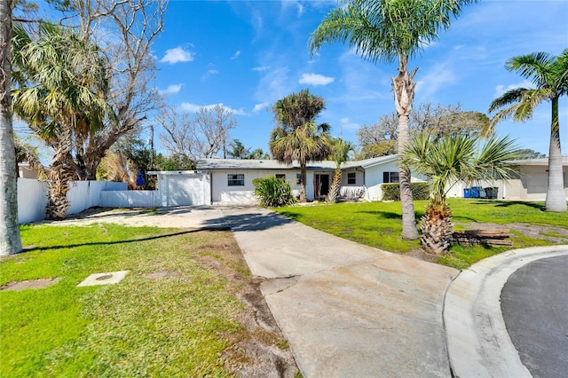 ranch-style house featuring a front yard, driveway, and fence