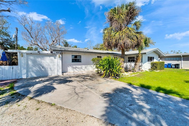 ranch-style house with an attached garage, driveway, a front lawn, and fence