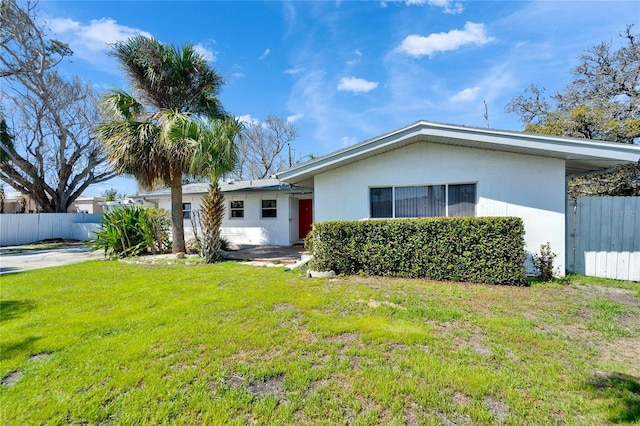 view of front of home with fence and a front lawn