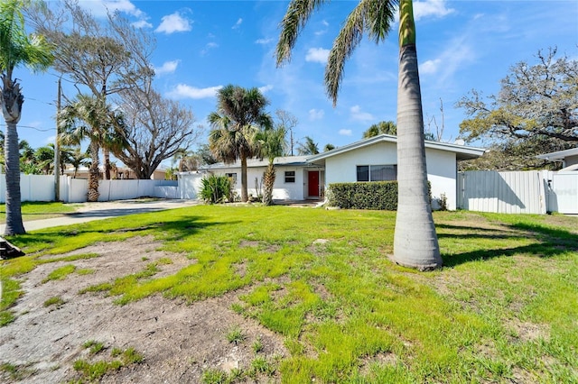 view of front facade with driveway, a gate, fence, and stucco siding