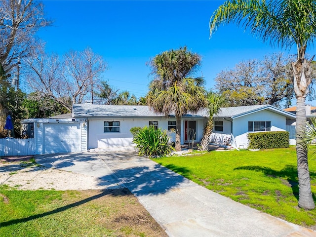 single story home featuring stucco siding, a front yard, fence, a garage, and driveway