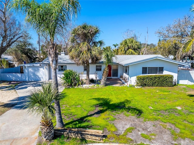 single story home with stucco siding, a front yard, fence, a garage, and driveway