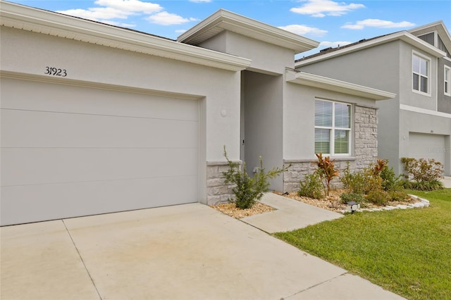 view of front of property featuring a garage, stone siding, concrete driveway, and stucco siding