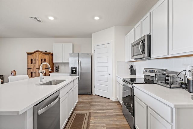 kitchen featuring a sink, visible vents, white cabinets, light countertops, and appliances with stainless steel finishes