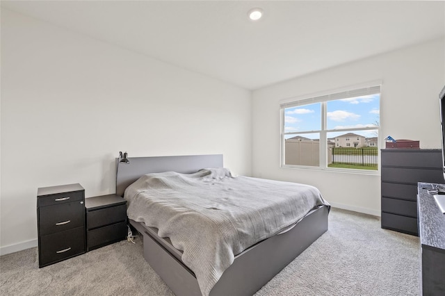 bedroom featuring baseboards and light colored carpet