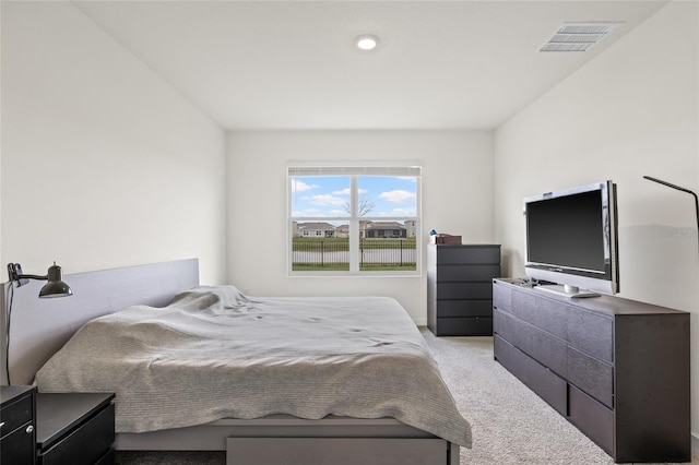 bedroom featuring visible vents and light colored carpet