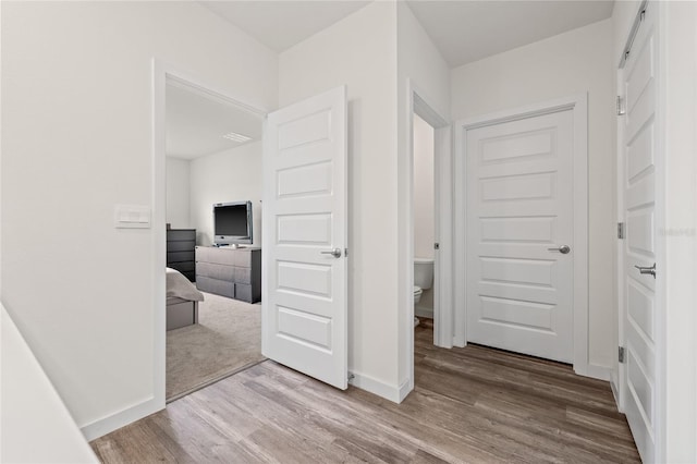 hallway with baseboards and wood finished floors