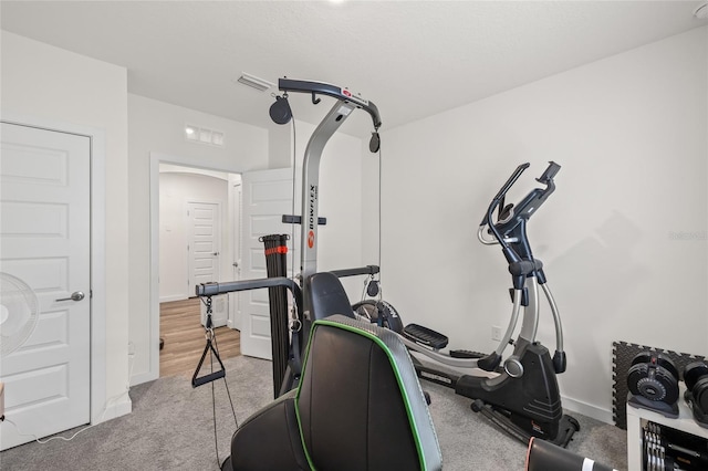 exercise room featuring carpet, visible vents, and baseboards