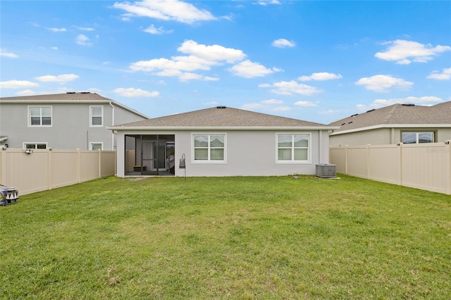 back of property with a lawn, a sunroom, a fenced backyard, cooling unit, and stucco siding