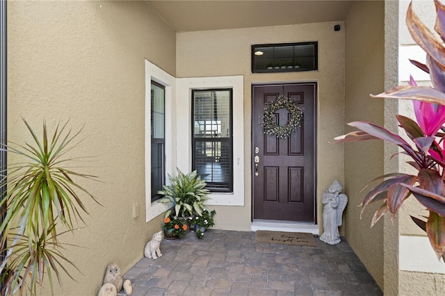 property entrance with stucco siding