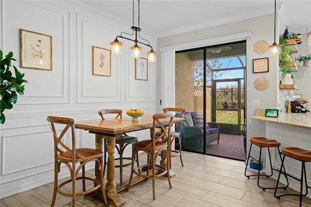 dining area featuring a decorative wall and ornamental molding