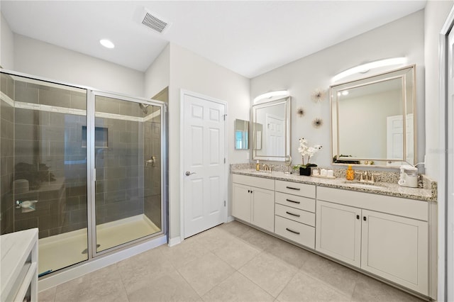 full bath featuring visible vents, a stall shower, a sink, tile patterned flooring, and double vanity