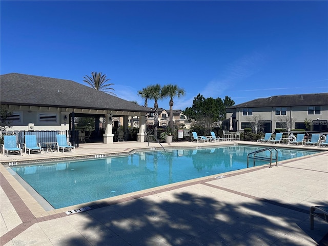 community pool featuring a patio and fence