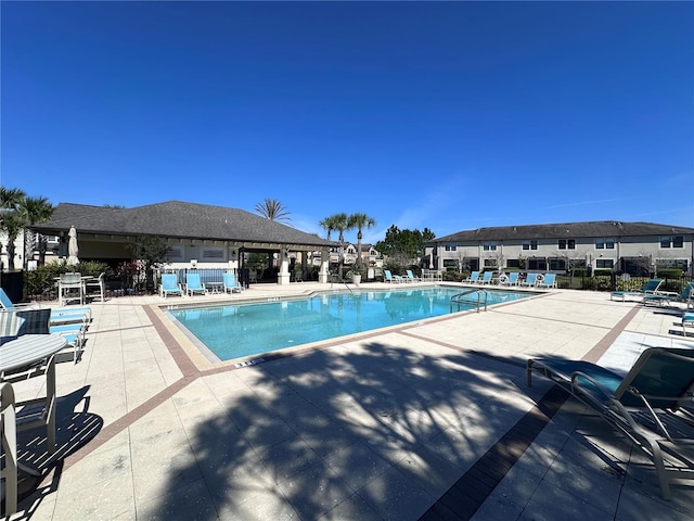 pool with fence and a patio area