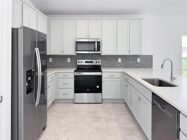 kitchen featuring a sink, white cabinetry, light countertops, appliances with stainless steel finishes, and decorative backsplash