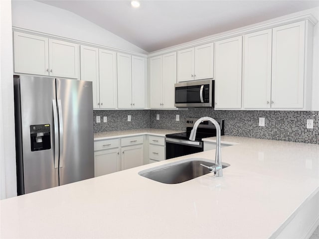 kitchen featuring lofted ceiling, light countertops, appliances with stainless steel finishes, and tasteful backsplash